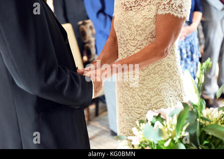 Paar exchange Trauringe am Tag ihrer Hochzeit Stockfoto