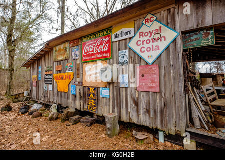 Alte Kabine Außenwand mit antiken Zeichen in ländlichen Alabama, USA hängen. Stockfoto