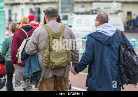 Paar mittleren Alters, Männer halten sich an den Händen in Brighton, East Sussex, England, UK. Stockfoto