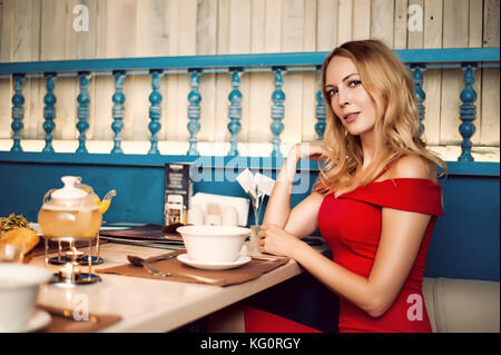 Junge schöne Mädchen essen Suppe in der orientalischen Restaurant und trinken Tee. Sie am Tisch sitzen, Kamera und Lächeln. Stockfoto