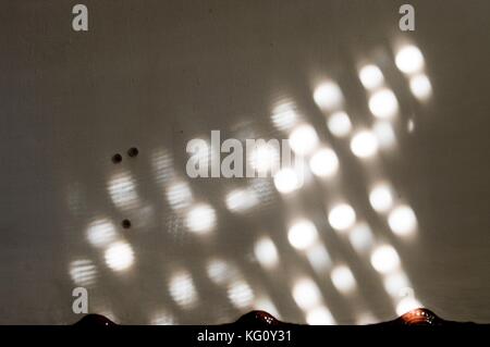 Lichtpunkte in einer Wand reflektiert Stockfoto