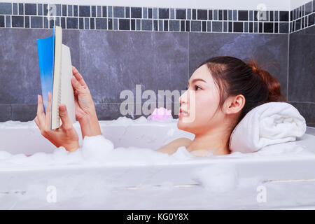 Frau mit Buch in der Wanne im Bad Stockfoto