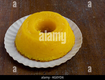 Nahaufnahme auf quindim, einem leckeren gelben brasilianischen Dessert mit Kondensmilch und Eier auf grunge Holztisch gemacht Stockfoto