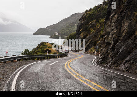 Kurvenreiche Straße entlang des Lake Wakatipu führt in Neuseeland Südinsel an einem regnerischen Tag in Queenstown Stockfoto