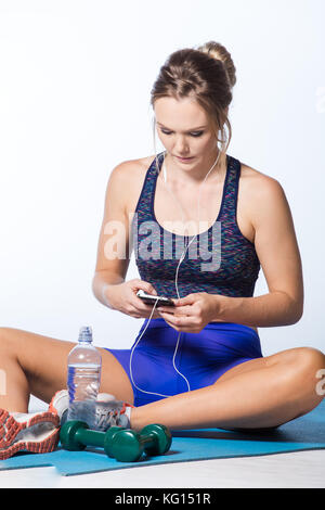 Weibliche fitness Modell Ausruhen nach einem intensiven Training und nehmen einige ein selfie im Spiegel der Fitnessraum. Stockfoto