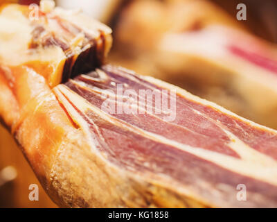 Jamon Serrano. Traditionelle spanische Schinken in den Markt schließen. schweinekeule Schinken auf Tabelle. Fleisch im Restaurant innen. Ganze jamon stand. Selektive foc Stockfoto