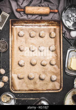 Cookies form Kugeln auf backblech Zubereitung am Küchentisch Hintergrund mit Zutaten und Teig rollen, Ansicht von oben Stockfoto