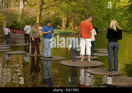 Touristen zu Fuß auf Holz- Stepping Stones. Frühling im Keukenhof Lisse, Niederlande. Auch als der Garten Europas bekannt, ist einer der größten Blume der Welt die Gärten. Stockfoto