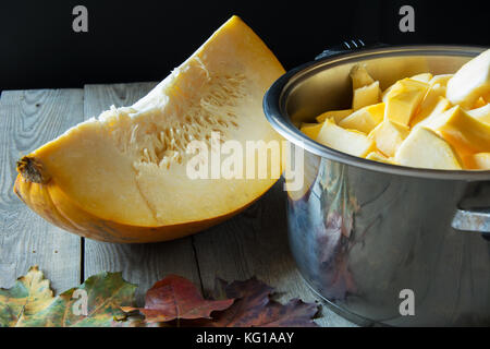 Kürbis Keil, ein Topf mit Kürbis bits und Herbstlaub auf einem Holztisch Stockfoto