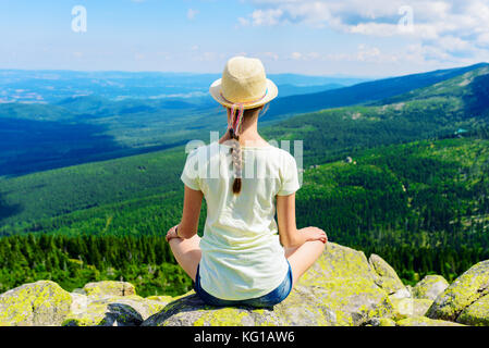 Young Travel Mädchen sitzen auf dem Rock Mountain, entspannen - yoga Wanderer Mädchen entspannen und genießen Blick auf das Tal Stockfoto