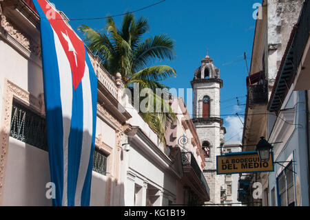 Die kubanische Flagge schmückt die Wände in der Calle Empedrado unterstützt von einem Glockenturm der Kathedrale von San Cristobal, Habana Vieja, Havanna, Kuba Stockfoto