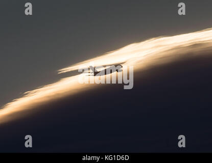 Frankfurt Main, Deutschland. November 2017. Ein Flugzeug fliegt während der Sonnenaufgangsstunden über Frankfurt am Main, Deutschland, 02. November 2017. Frank Rumpenhorst/dpa/Alamy Live News Stockfoto