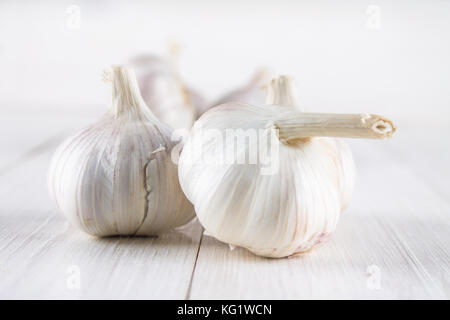 Knoblauchzehen und Knoblauch Zwiebel auf einem weißen Tisch Stockfoto