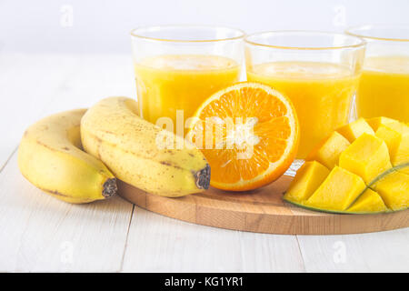 Gelbe smoothie Mango, Banane und Orange auf einem weißen Tisch Stockfoto