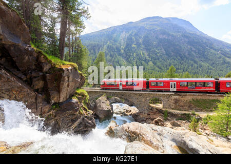 Bernina Express Zug neben Lake Creek, morteratsch, Engadin, Kanton Graubünden, Schweiz, Europa Stockfoto