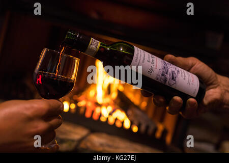 Flasche und Glas Wein vor dem Kamin, San romerio Alp, brusio, Puschlav, Kanton Graubünden, Schweiz, Europa Stockfoto