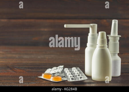 Nasenspray, nasale Tropfen, Tabletten im Blister, Süßigkeiten aus dem Husten auf dem Tisch. moderne Medikamente gegen Erkältungen, Grippe. Behandlung der Krankheit. Stockfoto