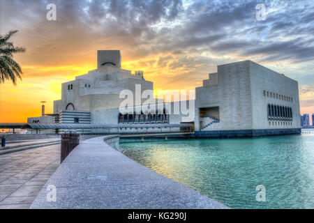 Museum für Islamische Kunst in Doha, Katar im Tageslicht Außenansicht mit Arabischen Golf im Vordergrund und Wolken im Himmel im Hintergrund