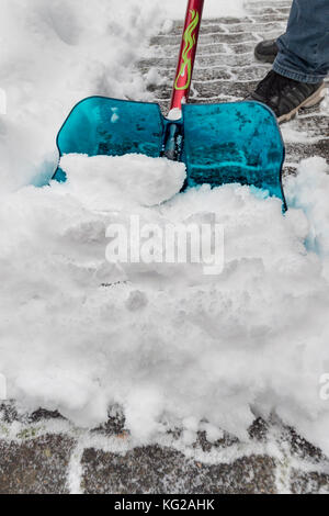 Mann Schnee vom Bürgersteig Stockfoto