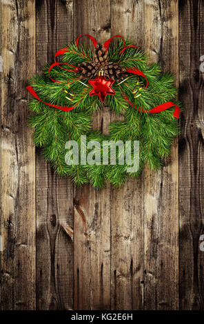 Weihnachten Kranz aus Tannenzweigen und rote Kugeln auf Holz- Hintergrund Stockfoto