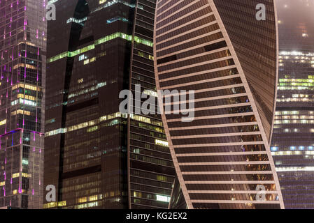 Abstrakte hi-tech-Hintergrund von Fragment moderne elevation Büro Gebäude aus Stahl und Glas mit Lichtern in der Nacht in die Nebelscheinwerfer eingeschaltet Stockfoto