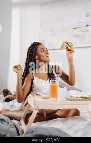 Frau essen Frühstück im Bett Stockfoto