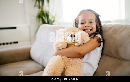 Niedliche kleine Mädchen spielen mit Teddybär Stockfoto