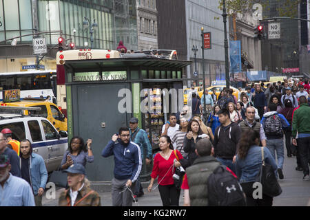 Massen von Menschen gehen auf 42nd Street vorbei an der New York Public Library bei der abendlichen Rush Hour in Midtown Manhattan Stockfoto