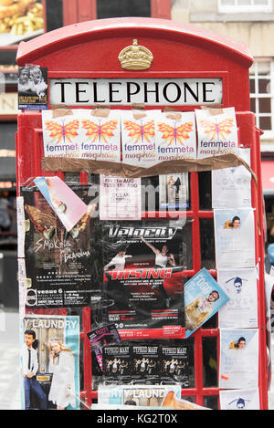 Eine rote Telefonzelle auf der Royal Mile in Edinburgh im Flyer Förderung Festival Fringe zeigt. Stockfoto