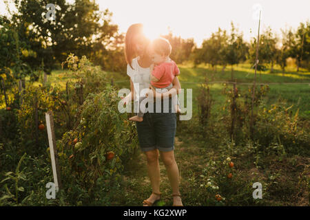 Mutter und Tochter im Garten pflücken Tomaten Stockfoto