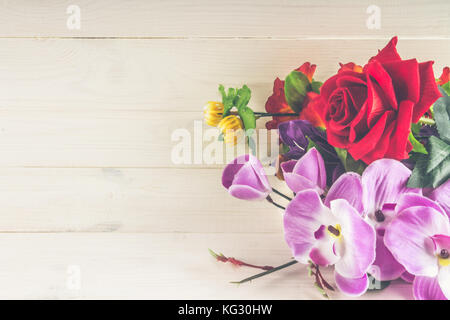 Verschiedene Künstliche Blumen auf weißem Holz- Hintergrund. Stockfoto