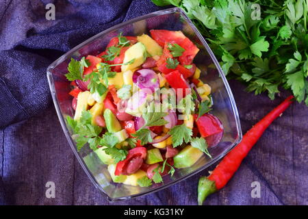 Frische helle mexikanischer Salat mit Tomaten, Avocado, rote Bohnen, Mais, Paprika, roten Zwiebeln, Zitrone, Chili Olivenöl Petersilie Stockfoto