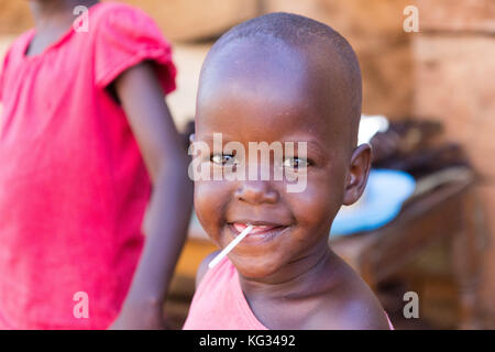 Einen lächelnden kleinen Jungen mit einem Lutscher. Stockfoto