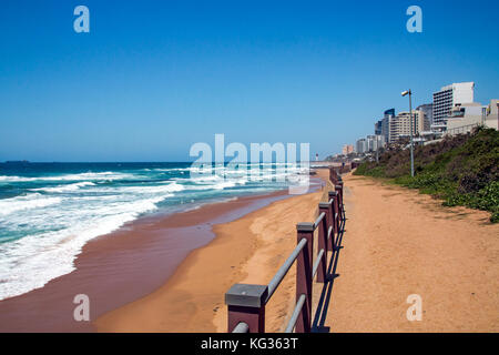 Küstenlandschaft von grünen Dünenvegetation Strand und Meer gegen Gewerbe- und Wohnbauten und blauer Himmel in Umhlanga in der Nähe von Durban in Südafrika af Stockfoto