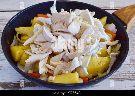 Gebratene Kartoffeln mit geschnittenen Austernpilzen in der Pfanne. Schritt für Schritt kochen Stockfoto