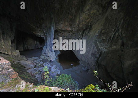 Ein Fotograf in der Cathedral Cave, Teil der Kathedrale Steinbrüche in Langdale, im Lake District, Cumbria, im Besitz und verwaltet von der National Trust, das kleine Netzwerk von miteinander verbundenen Steinbrüchen sind am besten für seine Hauptkammer bekannt, die Kathedrale, Die 40 Meter hoch steht und durch zwei Fenster neben dem Hauptbruch beleuchtet wird. Stockfoto