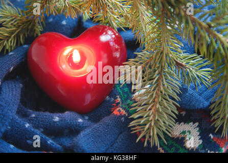 Herzförmige Kerze, Strick und a christmas tree branch Stockfoto
