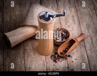 Schwarze Pfefferkörner und schwarzen Pfeffer auf hölzernen Hintergrund Stockfoto