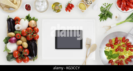 Digitale tablet oben auf weißem Schneidbrett mit Gemüse, Topf und Zutaten auf Küche weiß Holz- Arbeitsplatte, Kopieren, Ansicht von oben Stockfoto