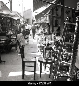 1950er Jahre, historische Bild, Menschen Browsen mit Ständen in einem der berühmten Pariser "Arche aux Puces", Flohmärkte, wo Antiquitäten, Möbel, Gemälde, Schmuck und alles andere Vintage steht zum Verkauf. Stockfoto