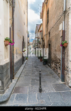 Typische traditionelle sizilianische Lane mit hohen Häusern, Basalt Pflastersteine und Blumen Stockfoto