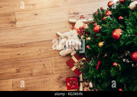Schön verpackt Weihnachten Geschenke und Knallbonbons neben einem Weihnachtsbaum gelegt. Weihnachten Hintergrund mit Dekorationen und Geschenkboxen einschalten lässt Stockfoto