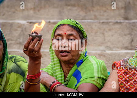 Ein Hindu woman holding a Metall Topf mit Wasser voll für bietet in den Ganges in Varanasi Ghat. Stockfoto