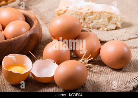 Eier und Kuchen auf einer Entlassung. ein Ei zerbrochen ist, ländlichen Stil, eine Nahaufnahme Stockfoto