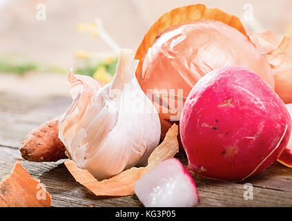 Heap Der rohe Gemüse hautnah. Garten Rettich, Zwiebeln, Knoblauch. kleine Schärfentiefe, Fokus auf Knoblauch Stockfoto