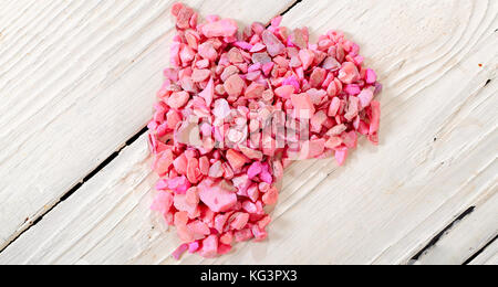 Herz aus rosa Steinen auf White Boards. Das Herz von kleinen rosa Steine auf den Brettern mit weißer Farbe bemalt festgelegt ist Stockfoto