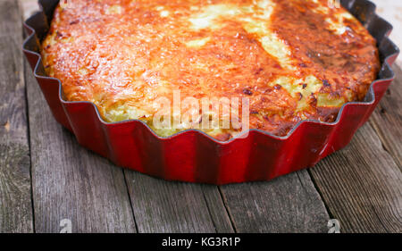 Pie auf einem Holztisch. Torte mit einem rötlichen Kruste in Form auf einem alten Holztisch Stockfoto