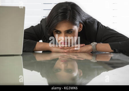 Betonte Geschäftsfrauen am Arbeitsplatz mit dem Gesicht nach unten auf dem Schreibtisch Stockfoto