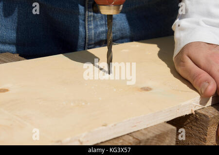 Holz-Bohrer. Bohrung in Board. Der Zimmermann Bohrer ein Loch in der Platine. Stockfoto