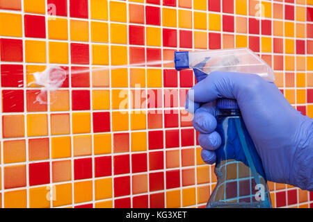 Person, Aufgaben im Bad zu Hause reinigen Fliesen- wand mit Spray Reinigungsmittel Stockfoto